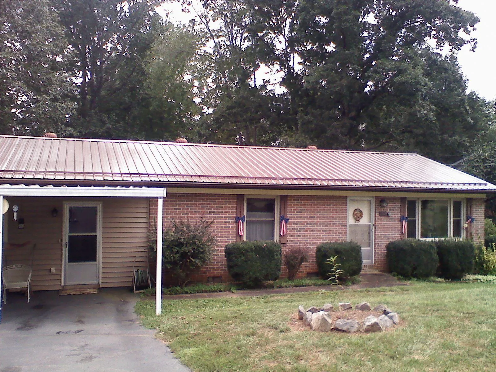 Bronze metal roof and carport on a brick ranch home — Roof Repair work by our crew in Richmond